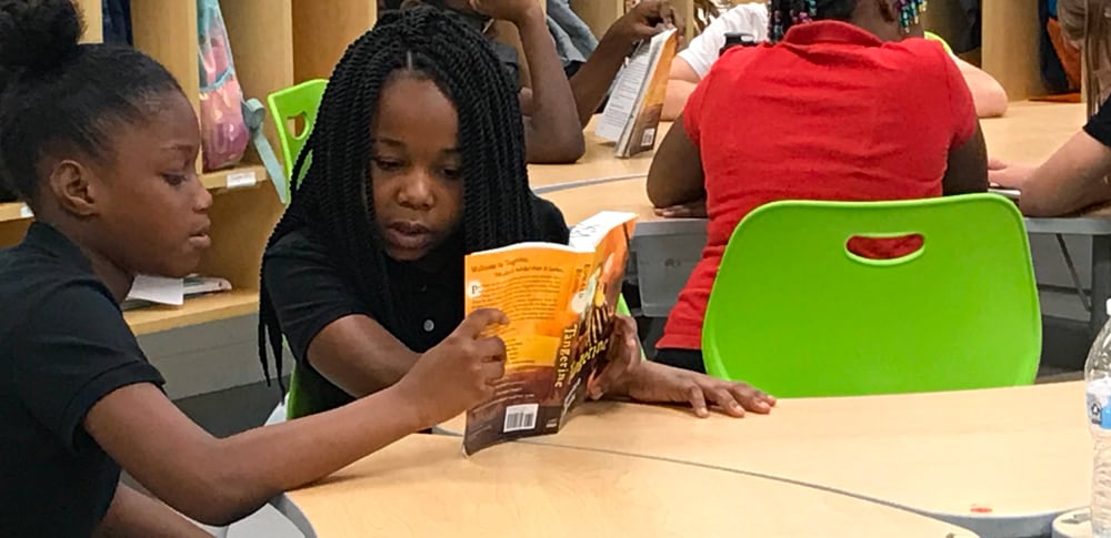Students share a book for reading